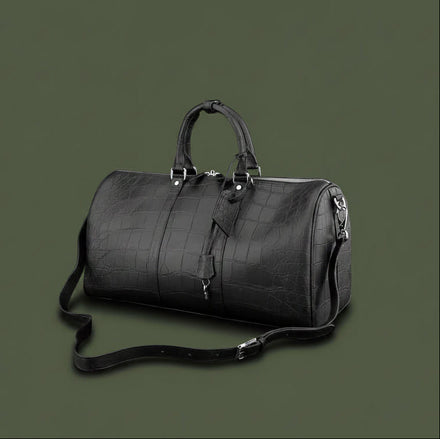 Load image into Gallery viewer, Black leather duffel bag with crocodile texture on a black background