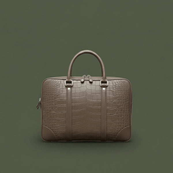 Brown crocodile-patterned briefcase on a black surface with a light gray background